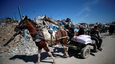 Palestinians transport aid provided by UNRWA at the Jabalia refugee camp in northern Gaza. Reuters
