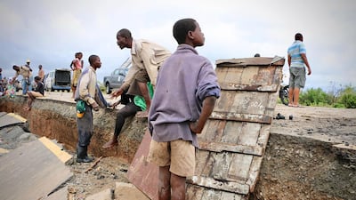 Locals stand on a damaged section of the road between Beira and Chimoio in Nhamatanda district, central Mozambique. AFP