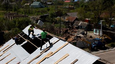 A roof damaged during Russia's invasion of Ukraine is rebuilt in Moshchun village, near Kyiv. Reuters