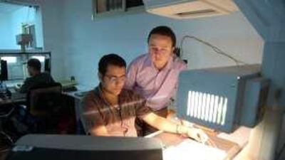 Ramy Habeeb, the founder and director of Kotobarabia, standing, at the firm's e-data factory in Cairo.