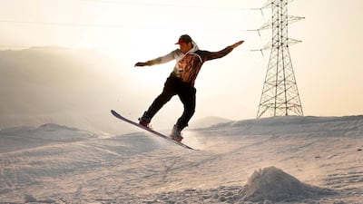 An Afghan snowboarder performs during a practice session on a snow-covered hilltop in Kabul. EPA