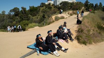 Spectators use special glasses to watch the solar eclipse near Griffith Observatory in Los Angeles. AP