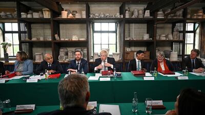 Boris Johnson straightens his tie before chairing a cabinet meeting at a pottery in Stoke-on-Trent on Thursday. Reuters