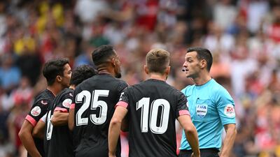 Sevilla's players argue with English referee Andy Madley. AFP