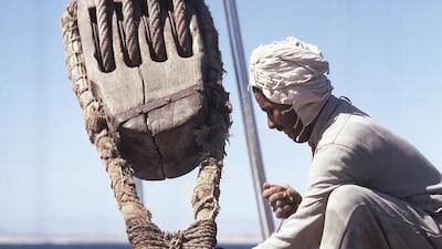 A sailor works with a boom’s great halyard block.