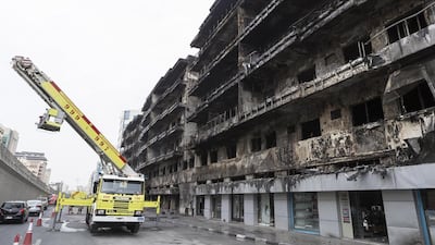 Civil Defence clear up after the blaze which swept through the Al Shamsi building in Deira. Antonie Robertson / The National