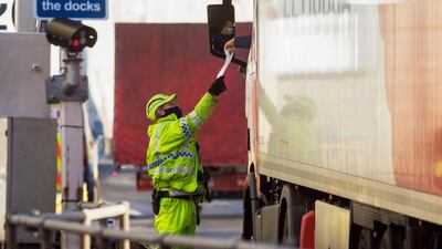 A policeman checks the paperwork of a truck driver. Bloomberg
