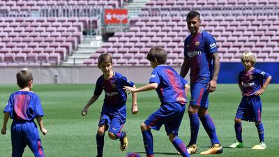 Barcelona's new Brazilian midfielder Paulinho football with young fans. Lluis Gene / AFP
