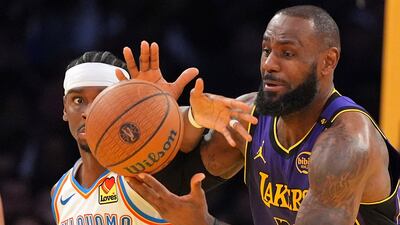 Oklahoma City Thunder guard Shai Gilgeous-Alexander, left, and Los Angeles Lakers forward LeBron James reach for a loose ball during the second half of an Emirates NBA Cup basketball game in Los Angeles on Friday November 29. AP