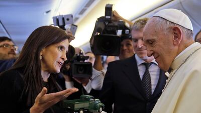 Pope Francis receives a reproduction of the car used by father Alberto Hurtado, a Chilean saint, as he meets reporters during his flight to Santiago. Alessandra Tarantino / AP