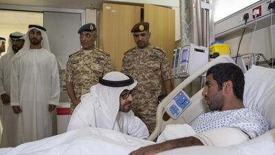Sheikh Mohammed listens to a serviceman’s story with Sheikh Hamdan bin Mohamed, back left, and Major General Essa Saif Al Mazrouei, Deputy Chief of Staff of the Armed Forces, back centre, looking on.