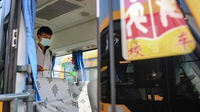 A worker sprays disinfectant inside a school bus in Yongchuan, in central China's Hunan province. AFP
