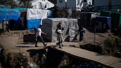 Migrants make their way through a makeshift encampment surrounding the Moria migrant camp on the Greek island of Lesbos on Tuesday. Reuters