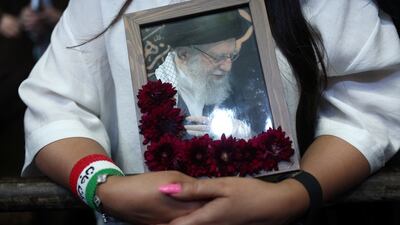 A woman holds a photo of Iran's late supreme leader, Ayatollah Ali Khamenei, during a rally in Tehran. Reuters