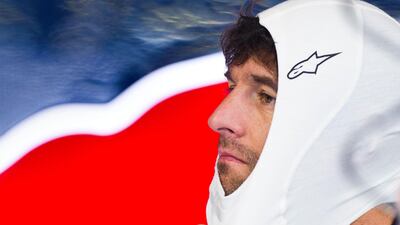 Mark Webber adjust his balaclava on his team's box during the first free practice at the European Grand Prix.