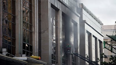 Firemen break a glass window of the Resorts World Hotel following an assault in Manila on June 2, 2017. Noel Celis / AFP