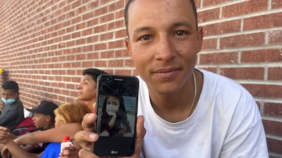 Dhean, 29, shows a picture of his daughter who is still in Venezuela