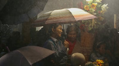 People gather in the rain to mark the 90th birthday of the Dalai Lama, the Tibetan spiritual leader and Buddhist monk, in McLeod Ganj, near Dharamsala, India. AFP