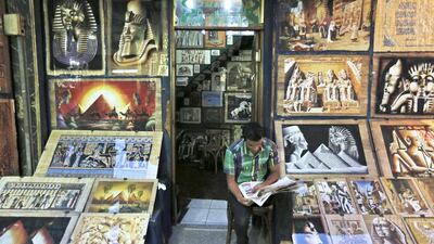 An Egyptian vendor reads a newspaper as he waits for customers in the Khan El-Khalili market, normally a popular tourist destination, in Cairo. Lefteris Pitarakis / AP Photo