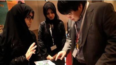 Kalthoom Al Awar, left, and Nujood Al Sayari from UAE University show their Tabkh Time app to Dr Paul Yoo from Khalifa University during the Mobile Application Contest in Abu Dhabi yesterday. Sammy Dallal / The National