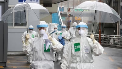 Medical staff members gesture as they arrive for a duty shift at Dongsan Hospital in Daegu, South Korea. Newsis via AP