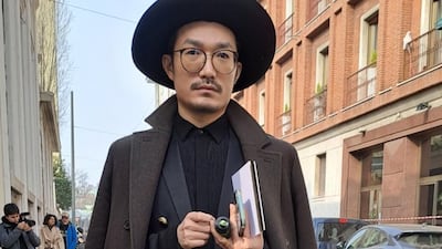 A well-dressed gentleman in a suit, coat and statement hat