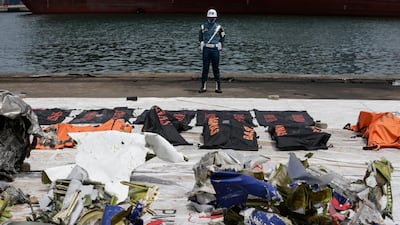 A member of Indonesian navy stands guards near the debris of the Sriwijaya Air flight SJ 182 plane crash recovered from the waters off Jakarta at Tanjung Priok port in Jakarta. EPA