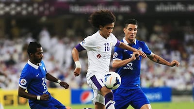 Omar Abdulrahman, centre, of Al Ain and Nawaf Shaker Alabid Neves Augusto Thaiago of Al Hilal tussle for the ball in the Asian Champions League semi-final second-leg match at Hazza bin Zayed stadium in Al Ain on Tuesday. Ravindranath K / The National