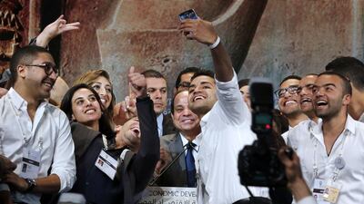 Volunteers crowd in for a selfie with the Egyptian president Abdel Fattah El Sisi, who earlier said that his country needed vast resources to develop quickly to make up for lost time. Amr Abdallah Dalsh / Reuters