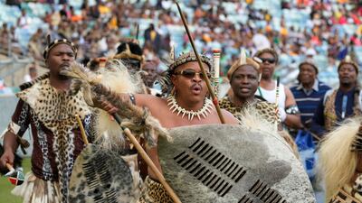 Zulu men sing and dance as they arrive for a coronation event. AP