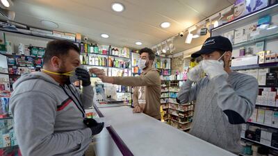 An Iraqi man checks a protective mask at a pharmacy in the holy Iraqi city of Najaf. AFP