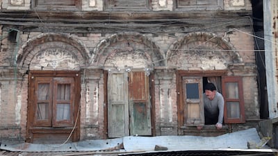 A Kashmiri man looks from a window of his home in Srinagar in August. EPA