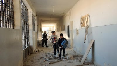 Syrian children search for their belongings at a school in Marea on the outskirts of Aleppo following airstrikes by government forces on December 22. Mohammed Al Khatieb / AFP