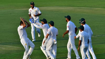 Pakistan cricketer Mohammad Abbas, left, celebrates with teammates after he dismissed Australia batsman Usman Khawaja. AFP