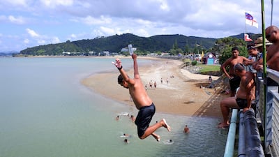 Children jump off the bridge in Waitangi, New Zealand. Getty Images