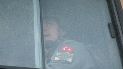 A Turkish military personnel looks out the window of a military vehicle as it enters the Bal al-Halwa crossing at the Syrian-Turkish border, in Idlib governorate, Syria. REUTERS