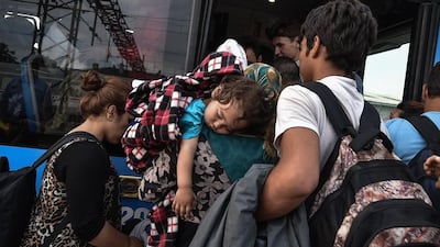 Refugees board a bus at the train station in Dugo Selo, near Zagreb, Crotia on September 17, 2015. Andrej Isakovic / AFP Photo