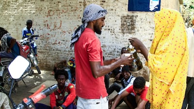 A woman serves tea to a Sudanese protester. AFP