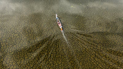 An aerial photograph of a local fishing boat in the Iraqi Hawizeh Marsh in Maysan province, southern Iraq, after water returned due to rainfall following a long period of drought on April 26, 2026. Hawizeh is a transboundary marsh shared by Iraq and Iran. (Photo by Hussein FALEH / AFP)