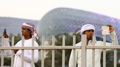 Emirati race fans capture the action on their cameraphones at Yas Marina Circuit. Valdrin Xhemaj/EPA