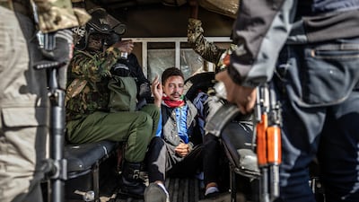 A protester sits in a pickup truck surrounded by Kenyan police officers after being arrested. AFP