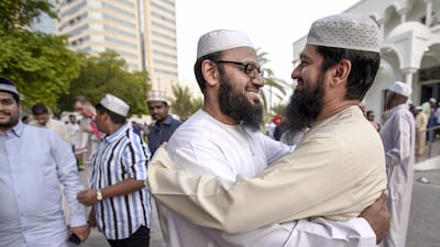 Two friends embrace after dawn prayers in central Abu Dhabi. Victor Besa / The National