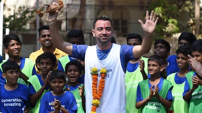 Former Barcelona and Spain midfielder Xavi is welcomed during the ground breaking ceremony of an astro-turf football pitch in Mumbai.