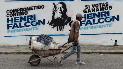 A worker passes by an electoral graffiti of Venezuelan opposition presidential candidate Henri Falcon, in Barquisimeto, Venezuela, on May 19, 2018 on the eve of the country's presidential election. Venezuela holds presidential elections on May 20, in which Maduro is seeking a second six-year term. / AFP / Luis Robayo