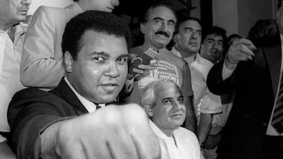 A smiling Muhammad Ali shows his fist to reporters during an impromptu news conference in Mexico City in this July 9, 1987 file photo. Jorge Nunez / Reuters