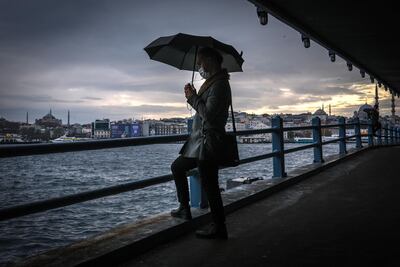 A man waits under the Galata Bridge with Hagia Sophia Mosque (L) and Yeni Mosque (R) in the background December 28, Istanbul. EPA