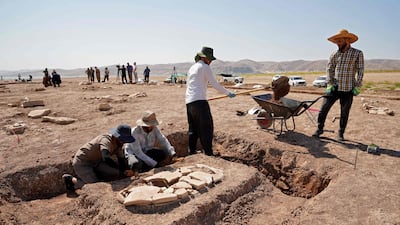 Kurdish members of the Dohuk Antiquities Department work on a grave on an archaeological site