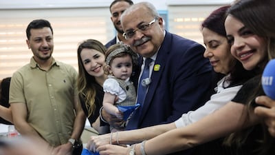 Ahmad Tibi, head of the Arab Movement for Change (Ta'al) party, casts his ballot with family members at a polling station in the mainly Arab city of Taibeh, on Monday. AFP