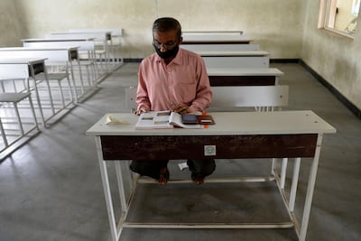 A teacher sits in an empty classroom as he prepares for online teaching at a government high school in Hyderabad on September 21, 2020, after the state government allowed 50 percent of staff at schools and colleges to resume duties for tele-counselling and online teaching amid Covid-19 coronavirus pandemic. AFP