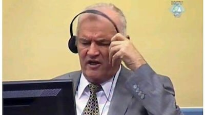 Former Bosnian Serb army chief Ratko Mladic removing his ear phones shortly before being taken from the courtroom in The Hague yesterday. Mr Mladic refused to enter a plea before a UN war crimes court. PHOTO COURTESY OF THE ICTY / AFP